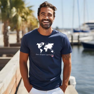 May include: A navy blue t-shirt with a white outline of the world map and the text "Our deepest apologies" with a small American flag.