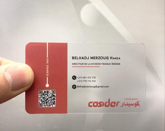 May include: A clear plastic business card with a red border. The card has the text "BELHADJ MERZOUG HAMZA" and "DIRECTEUR DE LA DIVISION TRAVAUX ÉNERGIE" in black text. The card also includes phone numbers, an email address, and the text "cosider كوسيدار Canalisaticos" in black text.