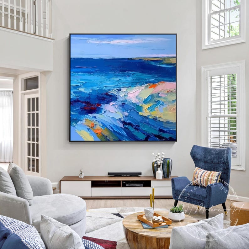 May include: Abstract painting of a seascape with blue, green, and white colors. The painting is framed and hanging on a wall in a living room.