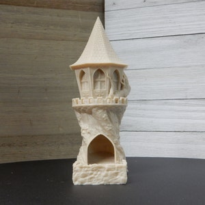 May include: A white, 3D printed tower with a pointed roof and a small opening at the base. The tower is designed to look like a tree with a house built into it.