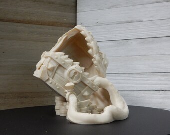May include: A white 3D printed treasure chest with a lock and keyhole, being swallowed by a white 3D printed monster with a mouth full of teeth. The chest is sitting on a stack of white 3D printed coins.