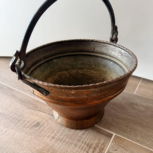 Peut inclure: Une tasse en céramique blanche avec une anse noire et le texte "But First, Coffee" en noir, dans une police manuscrite. La tasse est posée sur une surface blanche.