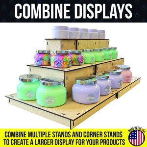 May include: A tiered wooden display stand showcasing various scented candles in glass jars with silver lids. The candles are in shades of green, purple, pink, and colorful tie-dye patterns. The text "COMBINE DISPLAYS" is at the top.