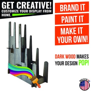 Peut inclure: Un pr&eacute;sentoir en bois &agrave; plusieurs niveaux pour exposer des articles. Le pr&eacute;sentoir est brut et peut &ecirc;tre peint. Le texte "GET CREATIVE! CUSTOMIZE YOUR DISPLAY FROM HOME. BRAND IT PAINT IT MAKE IT YOUR OWN! DARK WOOD MAKES YOUR DESIGN POP!" est visible sur l'image. Un pinceau est affich&eacute; &agrave; c&ocirc;t&eacute; du pr&eacute;sentoir. Un petit drapeau am&eacute;ricain se trouve dans le coin inf&eacute;rieur droit de l'image.
