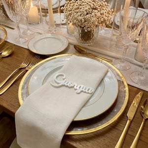 Marcadores de lugar para casamento em acrílico branco, com nomes de convidados personalizados.