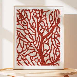 May include: A framed print of a red coral branch on a white background. The coral is stylized and has a graphic design aesthetic.