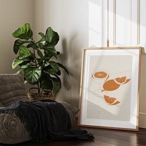 Peut inclure: Une impression d'art minimaliste repr&eacute;sentant une illustration stylis&eacute;e d'un verre avec une tranche d'orange et deux tranches d'orange sur un fond beige.