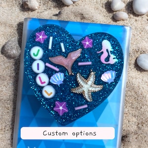 Adorno de resina personalizado en un accesorio para teléfono con tarjetero magnético, dije de sirena con brillantina oceánica hecho a mano, estética costera de estrella de mar y concha.
