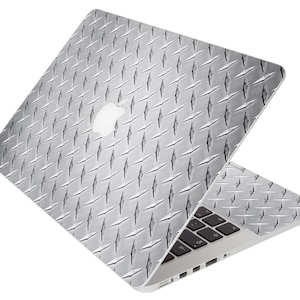May include: A silver laptop computer with a diamond plate pattern skin. The laptop is open and the keyboard is visible.