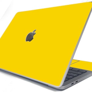 May include: A yellow laptop with an Apple logo on the lid. The laptop is closed and the screen is facing away from the viewer.