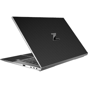 Może przedstawiać: Czarny laptop z wzorem z włókna węglowego i srebrnym logo Z na pokrywie. Laptop jest otwarty, a klawiatura jest widoczna.