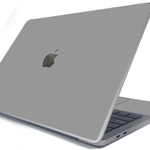 May include: A silver laptop computer with the Apple logo on the lid. The laptop is closed and the screen is facing away from the viewer.