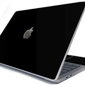 May include: A black laptop computer with a silver Apple logo on the lid. The laptop is open and the keyboard is visible.