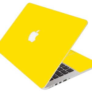 May include: A yellow laptop computer with an Apple logo on the lid. The laptop is open and the keyboard is visible.