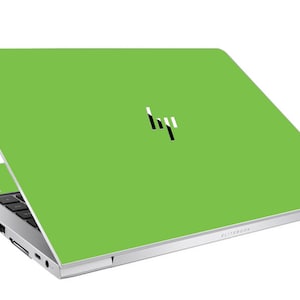 May include: A lime green laptop with the HP logo in black and white. The laptop is open, revealing the keyboard and ports. The word "ELITEBOOK" is printed on the bottom right corner of the laptop.
