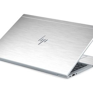 May include: A silver laptop computer with a brushed metal finish and the HP logo on the lid. The laptop is open and the keyboard is visible.