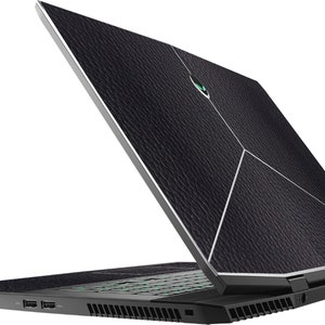 May include: Black laptop with a textured lid and a green logo. The laptop is open and the keyboard is visible. The laptop is on a white background.