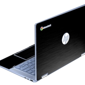 Puede incluir: Un portátil HP Chromebook negro con un acabado de metal cepillado. El portátil está abierto, revelando un teclado y un panel táctil azul claro. El logotipo de HP es visible en la tapa, junto con el logotipo de Chromebook.