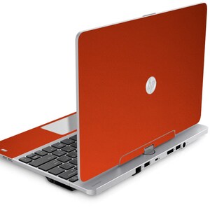 May include: A silver laptop with an orange lid. The HP logo is visible on the lid.