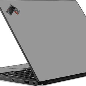 May include: A gray laptop computer with a black keyboard and a black Lenovo logo on the back.