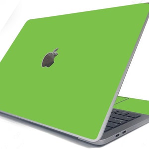 May include: A green laptop computer with the Apple logo on the lid. The laptop is closed and the screen is facing away from the viewer.