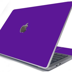 May include: A purple laptop computer with a silver Apple logo on the lid. The laptop is closed and the screen is facing away from the viewer.