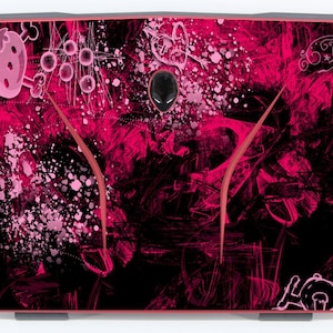 May include: A pink and black laptop skin with a graphic design featuring a strawberry, skulls, and other abstract shapes.