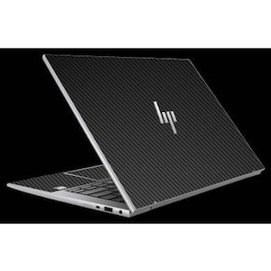 Puede incluir: Un portátil plateado con un patrón de fibra de carbono negro en la tapa y el área del teclado. El logotipo de HP es visible en plata. El portátil está abierto, mostrando el teclado y la pantalla.