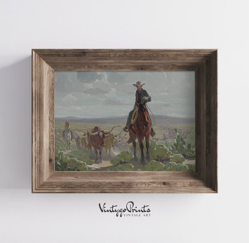 May include: A vintage painting depicting a cowboy on horseback leading a herd of cattle across a dusty landscape. The cowboy is wearing a hat and a long coat, and the cattle are brown and white. The painting is framed in a wooden frame.