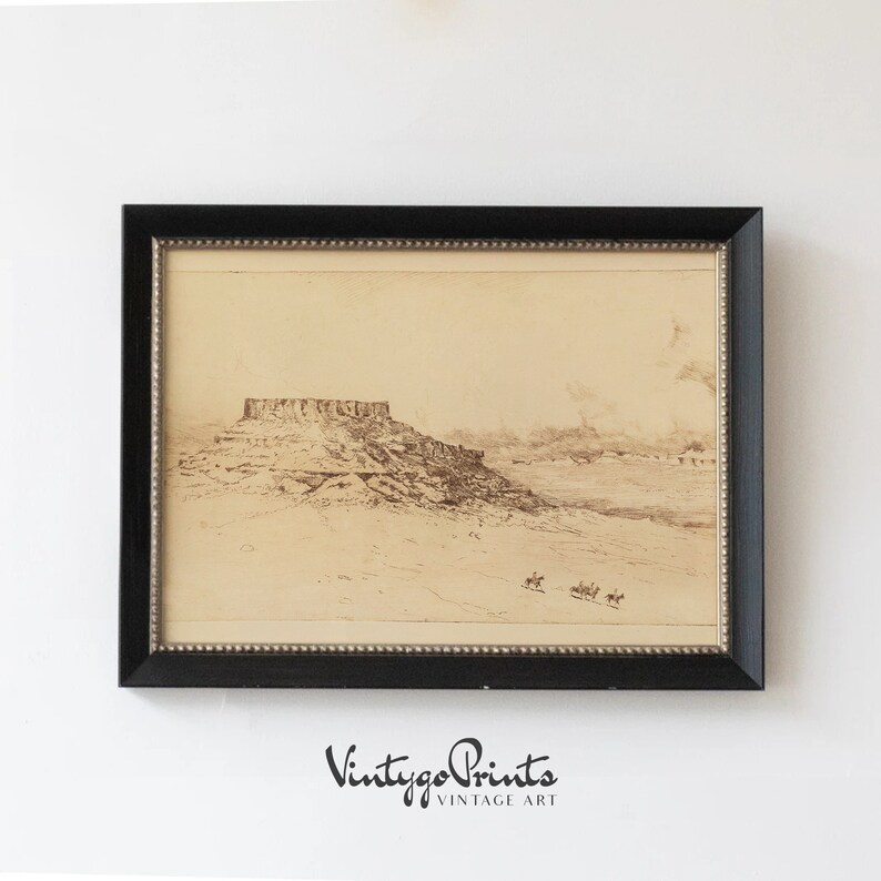 May include: A vintage black and white print of a landscape with a large rock formation in the distance. The print is framed in a black frame with a gold trim.