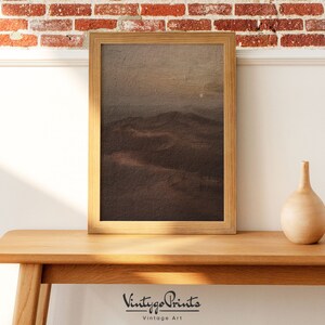 Puede incluir: Una pintura de paisaje enmarcada que representa una cordillera marr&oacute;n y gris bajo un cielo nublado. La pintura est&aacute; en un marco de madera con un acabado marr&oacute;n claro.