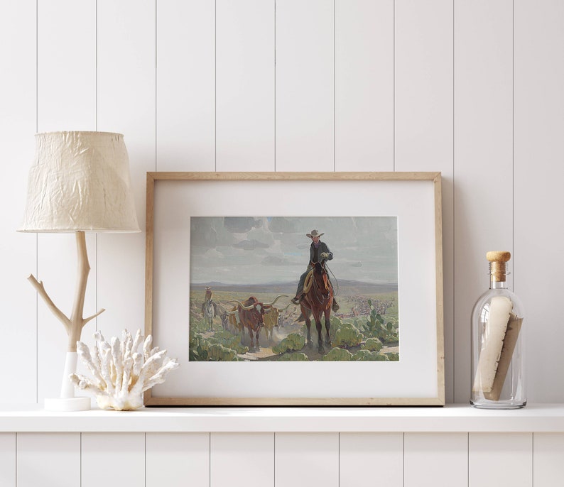 May include: A framed print of a painting depicting a cowboy on horseback leading a herd of cattle across a grassy plain. The sky is cloudy and the scene is set in a rural landscape.