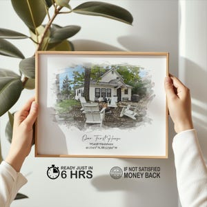 May include: A framed print featuring a watercolor-style image of a white house with Adirondack chairs. The text "Our First House" is below the image, along with the address and coordinates. The frame is a light brown color.