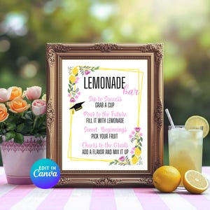 K&ouml;nnte beinhalten: Ein gerahmtes "Lemonade Bar"-Schild mit Text und floralen Akzenten. Das Schild enth&auml;lt S&auml;tze wie "Sip to Success" und "Cheers to the Grads". Ein Glas Limonade, Zitronen und Blumen sind im Hintergrund. Der Rahmen ist goldfarben.