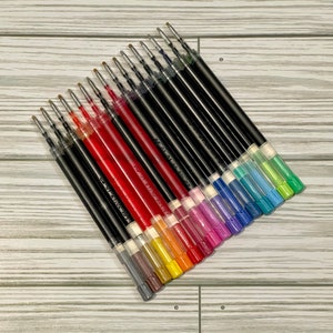 May include: A set of 18 colorful gel ink pen refills. The refills are black, red, orange, yellow, green, blue, purple, and pink. The refills are arranged in a fan shape, with the black refills at the top and the pink refills at the bottom.