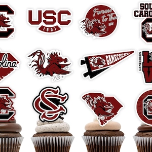May include: Twelve cupcake toppers featuring the University of South Carolina Gamecocks logo, mascot, and other related imagery. The toppers are printed on white paper and feature a variety of designs, including the school's colours of garnet and black.