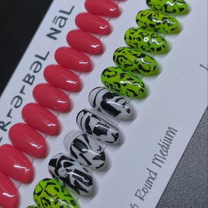 Puede incluir: Una colección de uñas postizas con varios diseños. Las uñas están dispuestas en filas, mostrando coral sólido, estampado de leopardo verde neón y patrones de cebra en blanco y negro. El texto "#236 Round Medium" es visible.