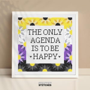 Może przedstawiać: Kwadratowy wzór do haftu krzyżykowego z białym środkiem i czarnym napisem THE ONLY AGENDA IS TO BE HAPPY. Obramowanie składa się ze stylizowanych kwiatów w poziome pasy w kolorach żółtym, białym, fioletowym i czarnym, w białej ramce.