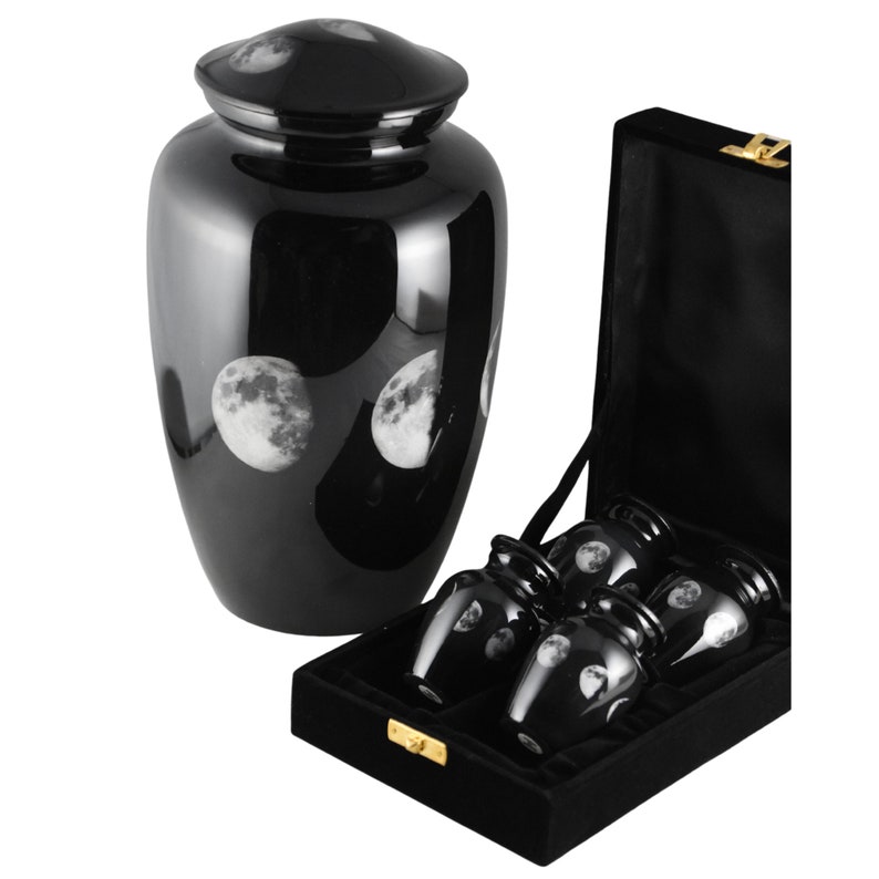 May include: Black cremation urn with a moon phases design. The urn comes with a velvet box and four smaller urns with the same design.