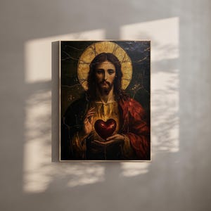 K&ouml;nnte beinhalten: Ein Vintage-Gem&auml;lde von Jesus Christus mit einem roten Herzen in der Hand. Das Gem&auml;lde ist in einem Holzrahmen gerahmt und hat einen dunklen Hintergrund.