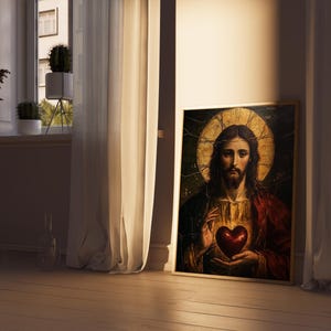 K&ouml;nnte beinhalten: Ein Gem&auml;lde von Jesus Christus mit einem goldenen Heiligenschein, der ein rotes Herz in seinen H&auml;nden h&auml;lt. Das Gem&auml;lde ist in Gold gerahmt und hat einen dunklen Hintergrund.
