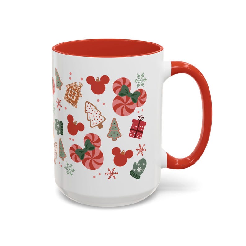 Puede incluir: Taza de cer&aacute;mica blanca con interior y asa rojos. La taza est&aacute; decorada con ilustraciones navide&ntilde;as, incluyendo casas de jengibre, &aacute;rboles de Navidad, cabezas con forma de Mickey Mouse, bastones de caramelo y copos de nieve. La taza mide aproximadamente 13 cm de alto.