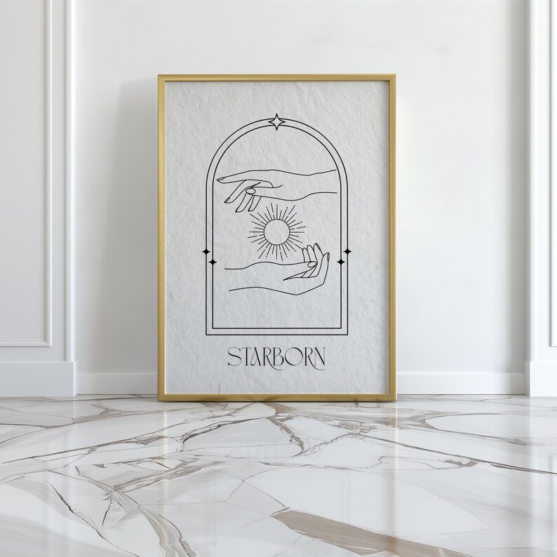 May include: A black and white line art print of two hands reaching towards a sun inside an archway. The print has a gold frame and the text "STARBORN" at the bottom.