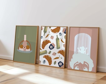 May include: Three framed prints with a green, white, and pink background. The green print features a chef with a pastry bag and a pastry. The white print features a pattern of croissants, olives, carrots, and bottles of olive oil. The pink print features a chef with a white chef hat.