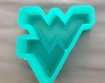 May include: A bright teal cookie cutter shaped like the West Virginia University Flying WV logo. The object features a thick, raised border and a hollow center, designed to cut dough into the specific letter W shape with a distinct serif style.