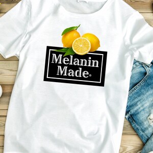 May include: White t-shirt with a graphic of lemons and the text "Melanin Made."