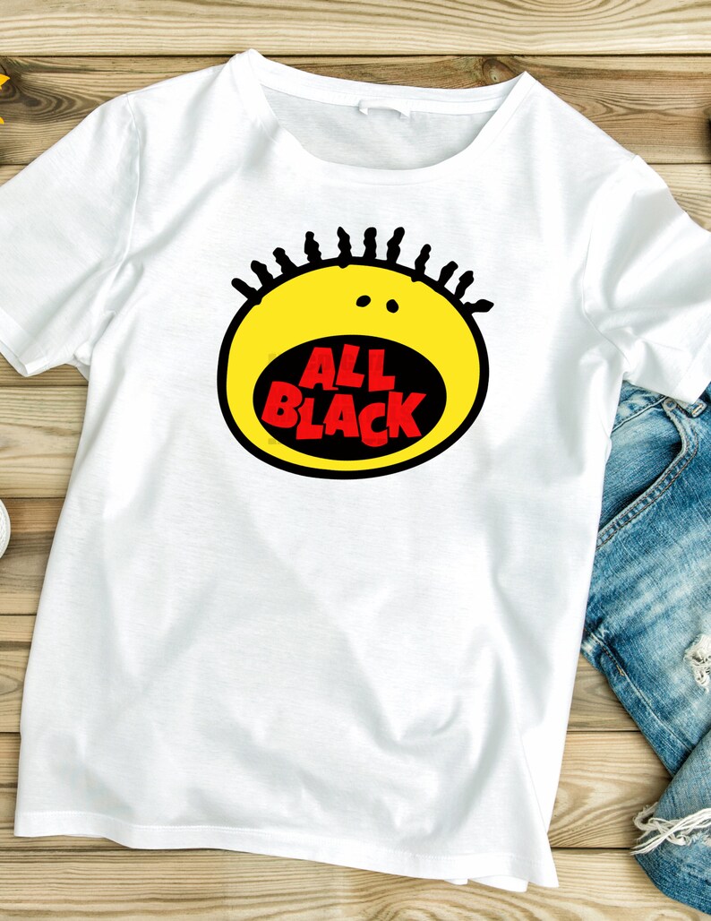 May include: White t-shirt with a yellow and black graphic of a cartoon face with the text "ALL BLACK" in red.