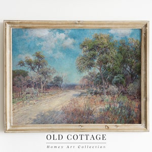 May include: A framed painting depicting a landscape scene with a dirt road winding through a forest of trees under a blue sky with white clouds. The painting is in a light wood frame.