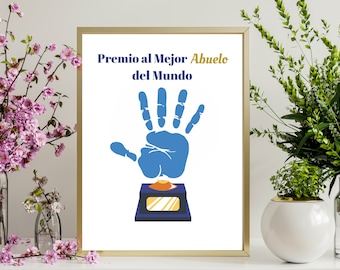Puede incluir: Una impresión enmarcada en blanco con el texto "Premio al Mejor Abuelo del Mundo" y una huella de mano azul sobre un trofeo azul y dorado.