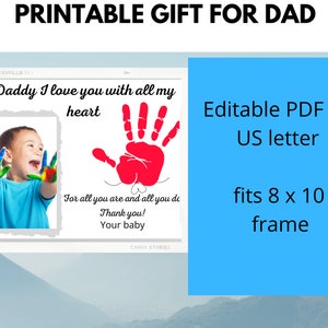 Puede incluir: Tarjeta imprimible para un padre con una huella de mano roja y una foto de un ni&ntilde;o con pintura colorida en las manos. La tarjeta dice "Pap&aacute; te quiero con todo mi coraz&oacute;n" y "Por todo lo que eres y todo lo que haces. &iexcl;Gracias! Tu beb&eacute;". La tarjeta es un archivo PDF editable que se ajusta a un marco de 20x25 cm.